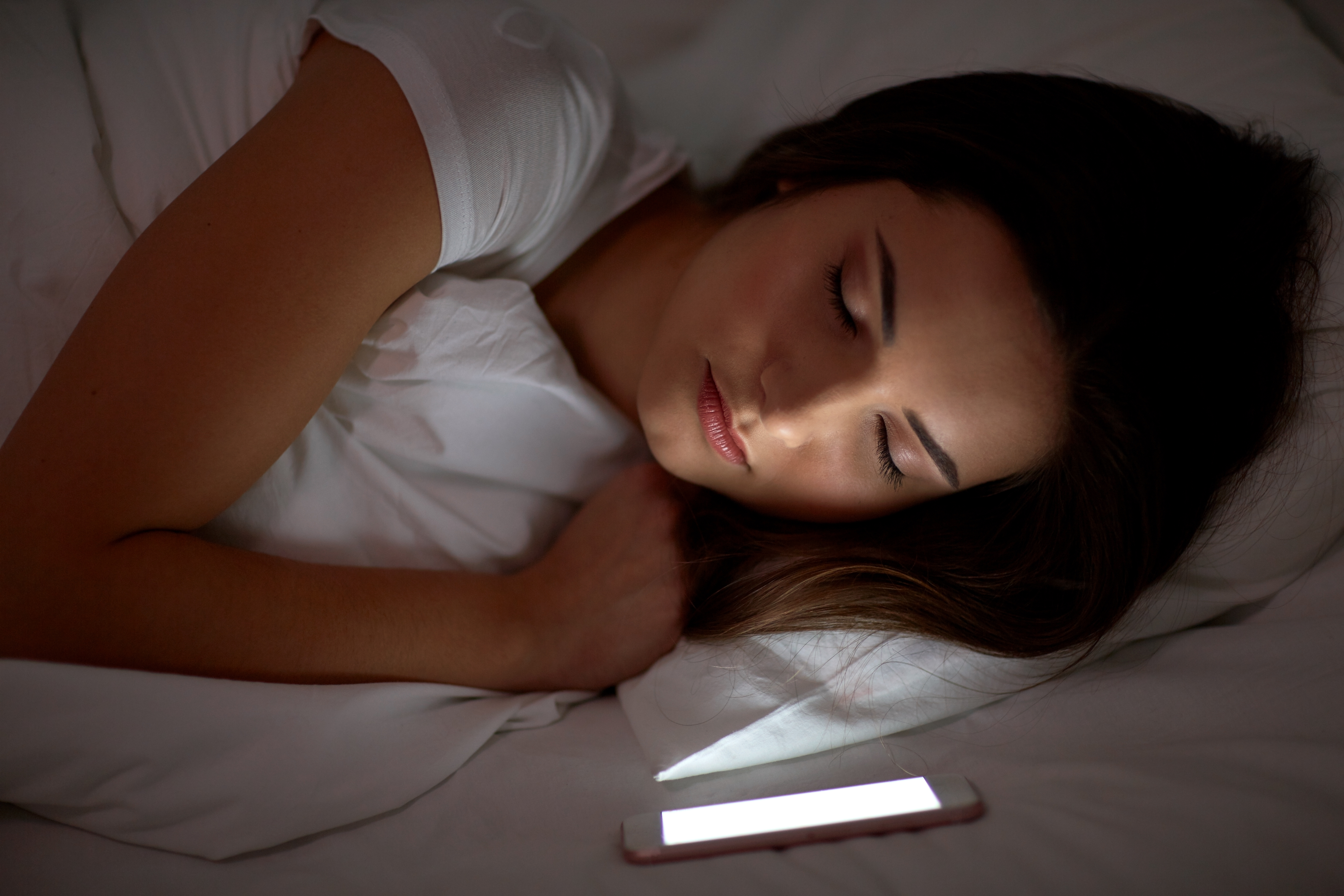 Ein Smartphone überwacht den Schlaf einer Frau